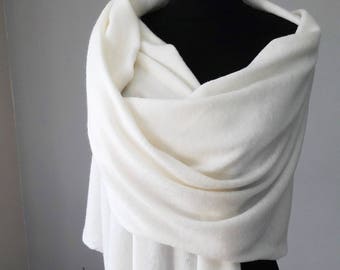 May include: A white knitted shawl draped over a mannequin. The shawl is soft and flowing, with a delicate texture.
