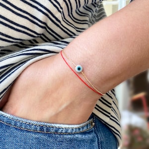 Pulsera de hilo rojo con ojo malvado en oro amarillo de 14 quilates