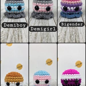 May include: A collection of six crocheted octopus plushies, each with a unique color scheme representing different gender identities. The plushies have large black eyes and a ruffled base. Text labels identify each octopus as Demiboy, Demigirl, Bigender, Aroace, Transgender, and Genderfluid.