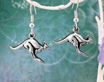 May include: A pair of silver dangle earrings featuring a kangaroo design. The kangaroos are in a leaping pose with their tails outstretched.