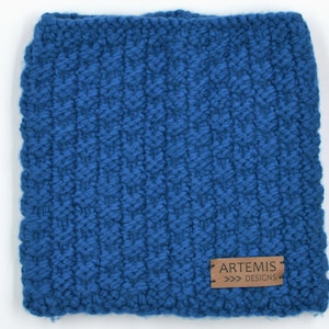 May include: A blue knitted neck warmer with a brown leather tag that reads "ARTEMIS >>> DESIGNS".