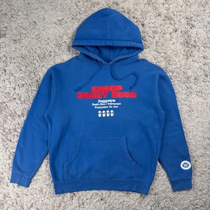 May include: A blue hoodie featuring the text "Snoop Doggy Dogg" in red. The sweatshirt has a front pocket, drawstring hood, and additional text and a graphic below the main text. The garment is a casual style.