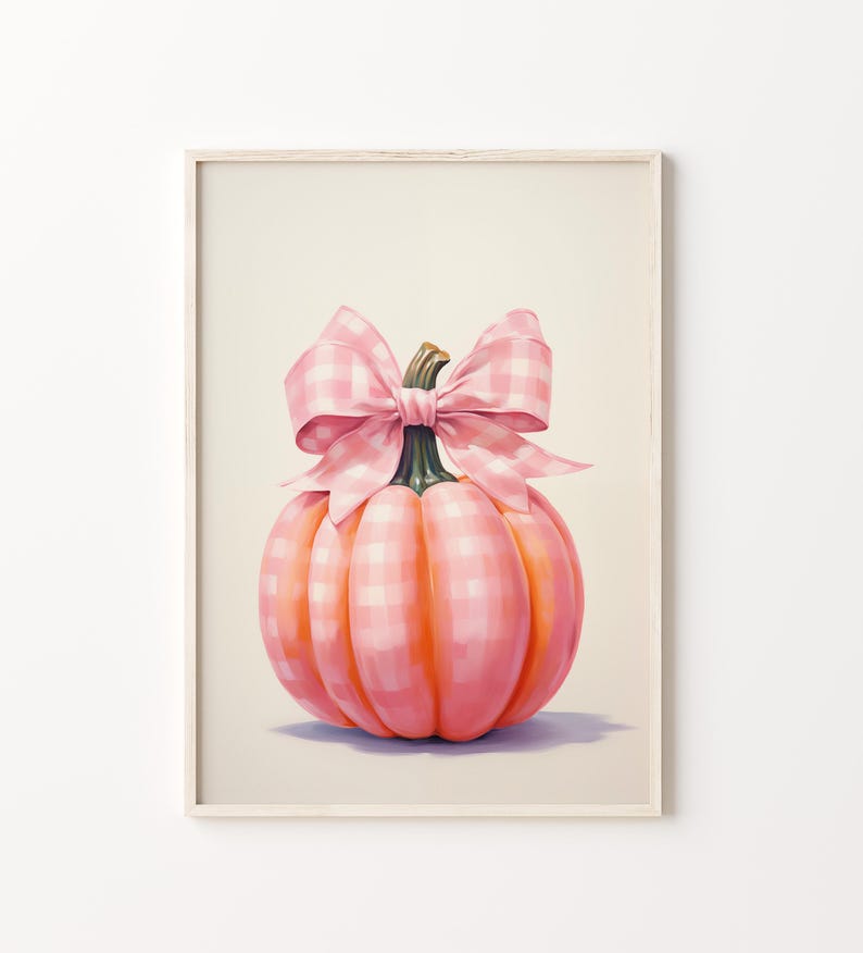 Puede incluir: Una impresi&oacute;n enmarcada que presenta una calabaza rosa con un lazo de cuadros. La calabaza es de un tono rosa vibrante con un patr&oacute;n a cuadros. El lazo es de cuadros rosas a juego. La obra de arte est&aacute; sobre un fondo blanco roto.