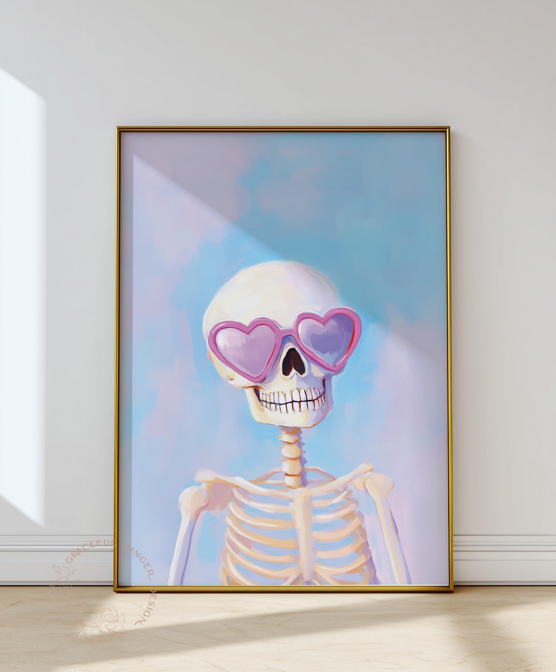 May include: A framed art print featuring a skeleton wearing pink heart-shaped sunglasses. The skeleton is set against a soft blue and purple background. The artwork has a whimsical and playful theme.
