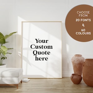 Peut inclure: Une affiche encadrée blanche avec le texte "Your Custom Quote here" en caractères gras noirs. L'affiche est appuyée contre un mur blanc avec un cercle brun dans le coin supérieur droit qui dit "Choose from 20 Fonts & 60 Colours".