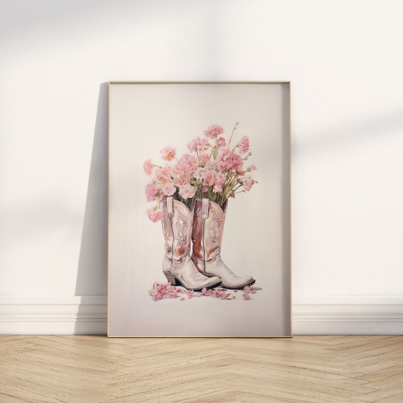 May include: A pair of white cowboy boots with pink floral accents. The boots are filled with pink flowers and petals are scattered on the floor.