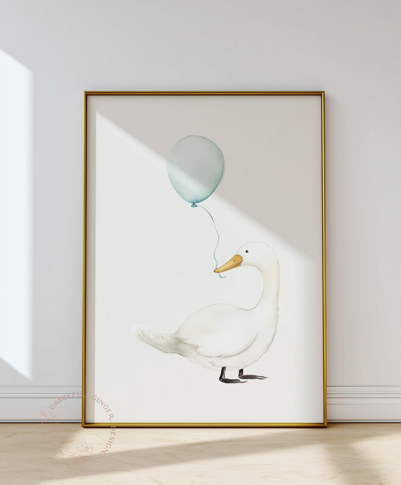 May include: Watercolor illustration of a white duck holding a light blue balloon. The artwork is framed in a gold frame and set against a white background. The duck has a yellow beak and black feet. The balloon is tied to the duck's beak.