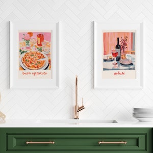 May include: Two framed illustrations of a table setting. The first illustration shows a pizza with the text "buon appetito". The second illustration shows a glass of wine and a bottle of wine with the text "salute".