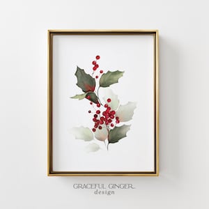 Puede incluir: Una impresión de arte de pared enmarcada que presenta una ilustración en acuarela de ramas de acebo con hojas de color verde oscuro y bayas de color rojo brillante. La obra está en un marco dorado fino. Debajo, el texto dice GRACEFUL GINGER design.