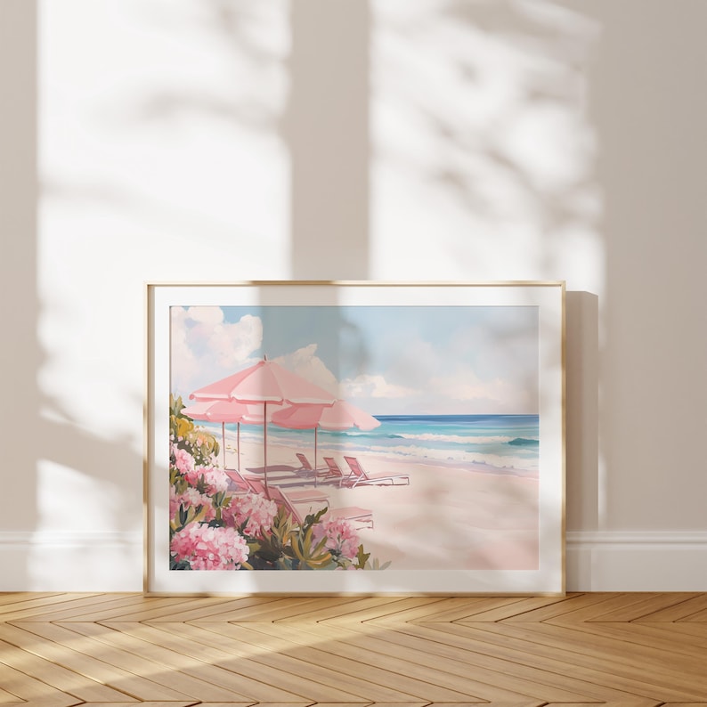 May include: A framed painting of a beach scene with pink umbrellas and lounge chairs. The beach is white sand and the ocean is blue. There are pink flowers in the foreground.