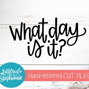 May include: Black and white hand-lettered text on a white wood background that reads "What day is it?" with a teal blue circle logo below that reads "Lettered by Stephanie" and a pink banner below that reads "Hand-lettered CUT FILES".