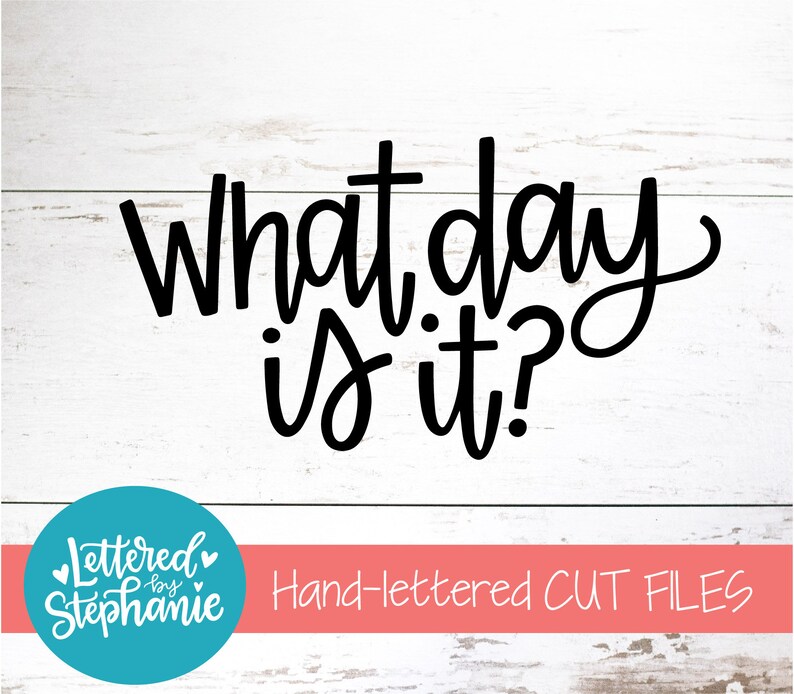 May include: Black and white hand-lettered text on a white wood background that reads "What day is it?" with a teal blue circle logo below that reads "Lettered by Stephanie" and a pink banner below that reads "Hand-lettered CUT FILES".