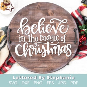 May include: A wooden round tray with a white inscription that reads "believe in the magic of Christmas". The tray has metal handles on the sides.