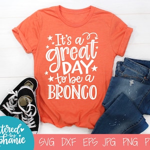 May include: Orange t-shirt with white text that reads "It's a great day to be a BRONCO".