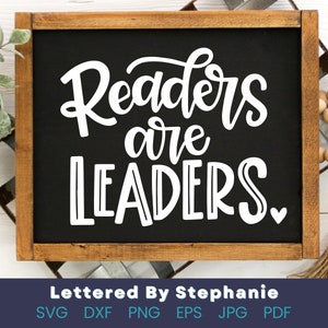 May include: A black chalkboard with a wooden frame displays the text "Readers are Leaders" in white cursive lettering with a small heart at the end.