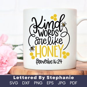 May include: White ceramic mug with a black and yellow design. The mug features the text "Kind words are like honey" with a bee and honeycomb graphic. The bottom of the mug reads "Proverbs 16:24".