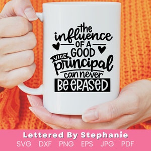 May include: White ceramic mug with black text that reads "The influence of a good principal can never be erased". The mug is held by a person's hands.