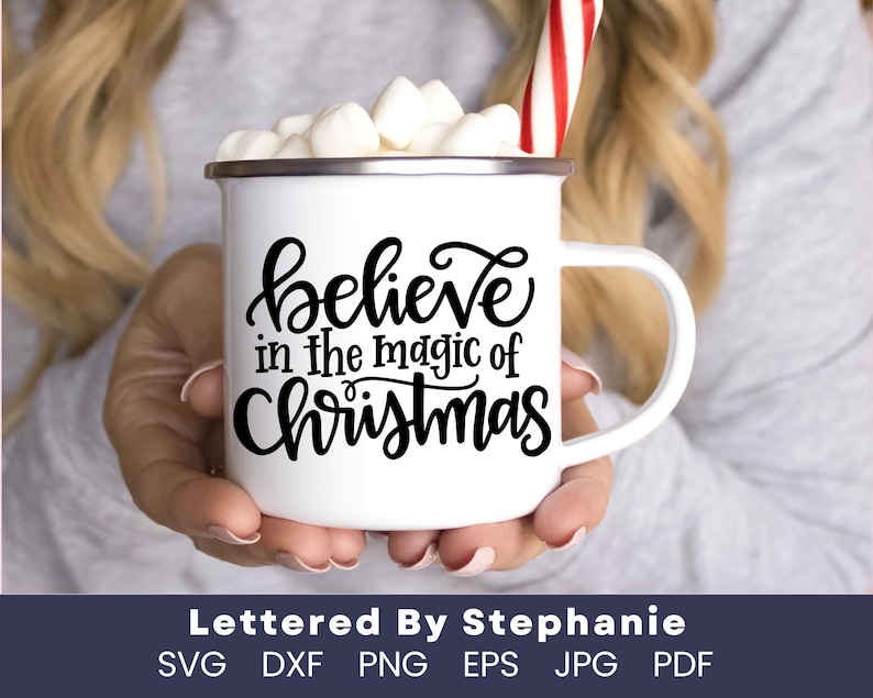 May include: White enamel mug with black lettering that reads "believe in the magic of Christmas". The mug is filled with marshmallows and a red and white candy cane.