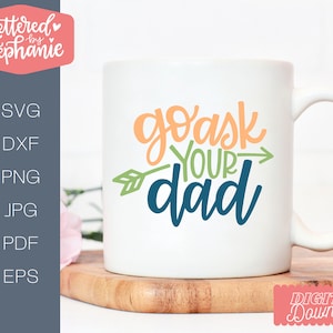 May include: White ceramic mug with a green arrow pointing to the right and the text "go ask your dad" in colorful lettering.