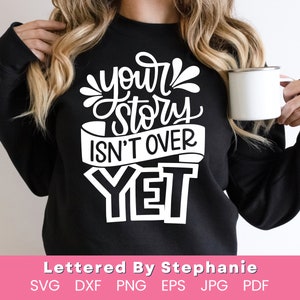 May include: A black sweatshirt with white text that reads "your story isn't over yet".