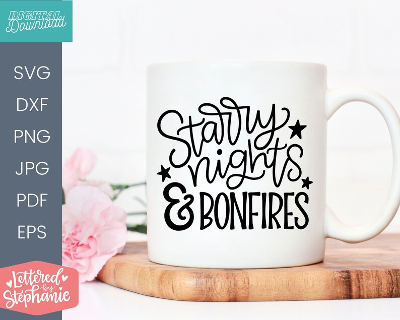 Op de afbeelding: Een witte keramische mok met zwarte tekst die "Starry Nights & Bonfires" zegt.