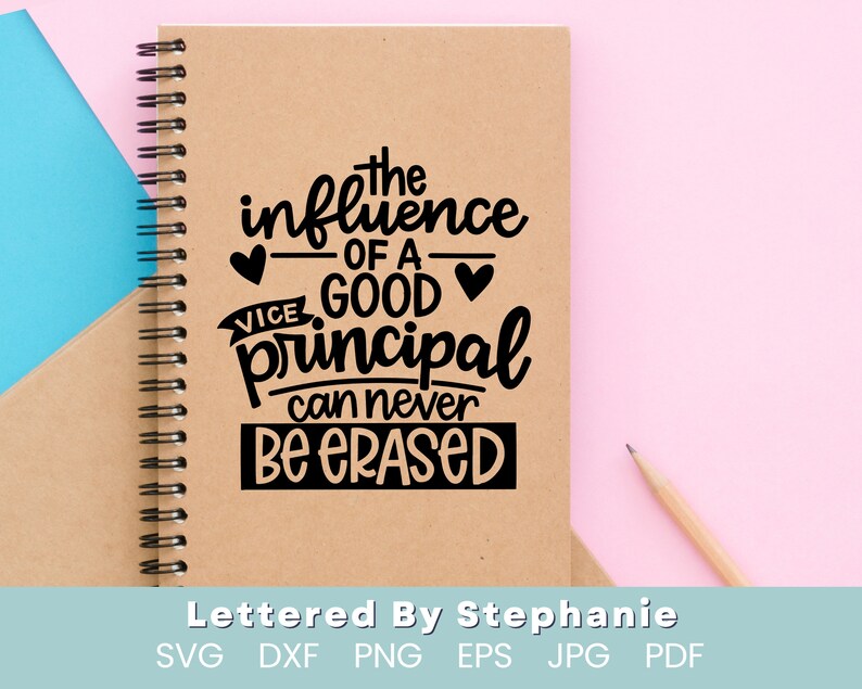 May include: A brown notebook with a spiral binding and a black quote that reads "The influence of a good vice principal can never be erased". The quote is surrounded by hearts. The notebook is on a pink surface.