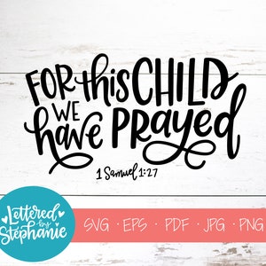 May include: Black and white calligraphy text on a white wood background. The text reads "For this child we have prayed" with the scripture reference "1 Samuel 1:27" below.