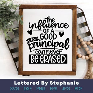 May include: A white sign with a brown wooden frame, featuring a black and white graphic that reads "The influence of a good principal can never be erased".
