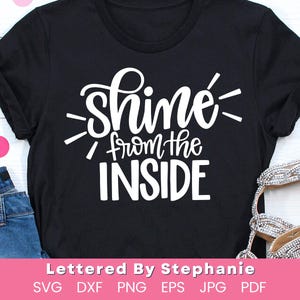 May include: Black t-shirt with white text that reads "Shine from the inside".