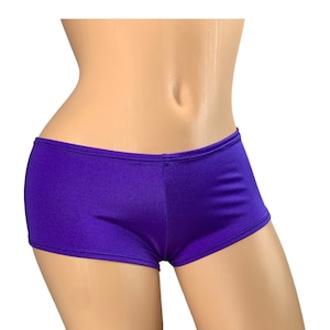 Puede incluir: Shorts de spandex morado de tiro bajo con un acabado liso y brillante.