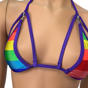 Puede incluir: Un top de bikini a rayas de color arcoíris y morado con tirantes ajustables y estilo halter.