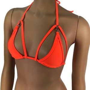May include: A bright orange bikini top with a halter style strap and a criss-cross design. The top has silver hardware.