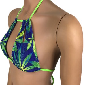 May include: A blue and green bikini top with a cannabis leaf pattern. The top has a halter neck design with neon green straps and trim. The fabric has a shiny, textured appearance.