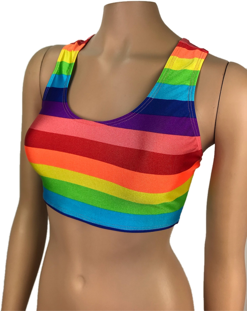 May include: A rainbow striped crop top with a scoop neck and racerback straps. The top is made of a stretchy, shiny fabric.