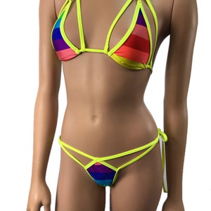 May include: A neon yellow and rainbow striped bikini with a halter top and a string bottom. The top has a criss-cross design and the bottom has a tie-side detail.