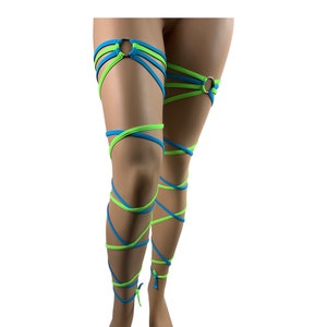 May include: A pair of leg wraps in blue and green colors, with a ring at the top of each wrap. The wraps are tied around the legs and are designed to be worn as a fashion accessory.