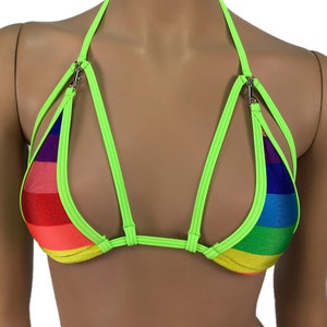 Puede incluir: Un top halter verde neón con rayas arcoíris y tirantes ajustables. Los tirantes tienen cierres metálicos.