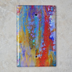 Puede incluir: Un diseño abstracto colorido con remolinos de pintura azul, roja, amarilla y morada. El diseño está impreso en una cubierta de interruptor de luz blanca.