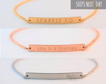 May include: Three stainless steel bracelets with chain links. The top bracelet is gold-toned with "SPARKLE XO" engraved. The middle bracelet is rose gold with "Life is a journey". The bottom bracelet is silver with "R+S".