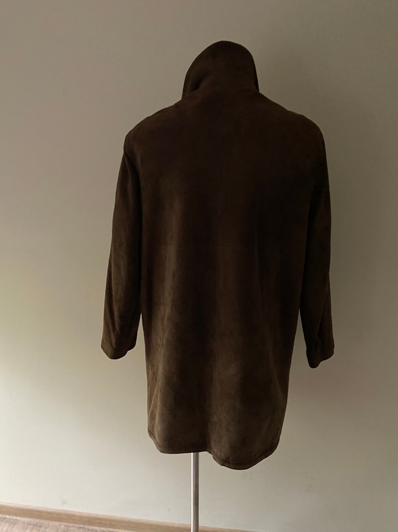 Puede incluir: Una chaqueta de ante marr&oacute;n con cuello alto y mangas largas.