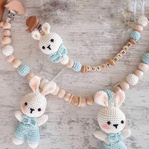 May include: Two crocheted bunny toys with blue and white outfits attached to wooden bead chains with the names "Yusuf" and "Eymen" spelled out in wooden letters.
