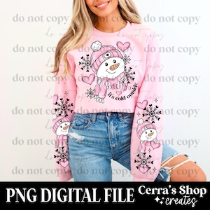 Puede incluir: Sudadera rosa claro con un diseño de muñeco de nieve con sombrero y bufanda. Incluye el texto "Baby, it's cold outside". Las mangas tienen diseños adicionales de muñecos de nieve y copos de nieve. También se ve "PNG DIGITAL FILE" y "Cerra's Shop creates".