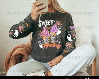 May include: Dark gray long-sleeved shirt with a Halloween-themed graphic. The design features two ice cream cones with skeleton hands, ghosts, spiderwebs, and the words "Sweet Spooky". The sleeves have additional Halloween graphics.