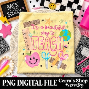 May include: A pale yellow t-shirt featuring the text It's a beautiful day to TEACH in pink and orange. The design includes a ruler, a pink smiling apple, blue scissors, a yellow pencil, a pink pair of scissors, and a globe graphic.