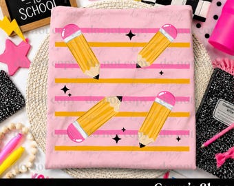 May include: A light pink t-shirt featuring a repeating pattern of yellow pencils with pink erasers, set against horizontal orange and pink stripes, accented with small black four-pointed stars scattered across the fabric surface.