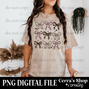 May include: A beige t-shirt featuring a grid of nine bow designs in various patterns and colors, including pink, leopard print, and checkered. The text "PNG DIGITAL FILE" is at the bottom, along with the shop name.