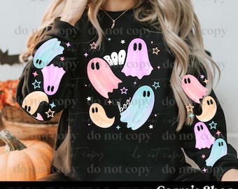 May include: A black long-sleeve sweatshirt featuring a graphic print of multiple pastel-colored ghosts in shades of pink, blue, and orange, interspersed with small stars and the text "BOO" written in a playful, white, bubbly font style.