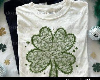 May include: Two t-shirts, one black and one cream-colored, are displayed. The cream-colored shirt features a large green lace clover design. The text "PNG DIGITAL FILE" and "Cerra's Shop creates" are at the bottom of the image. The theme is St. Patrick's Day.