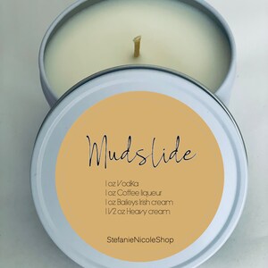 May include: White candle in a tin with a label that says "Mudslide" and lists the ingredients: 1 oz Vodka, 1 oz Coffee liqueur, 1 oz Baileys Irish cream, 1 1/2 oz Heavy cream. The label also says "StefanieNicoleShop".