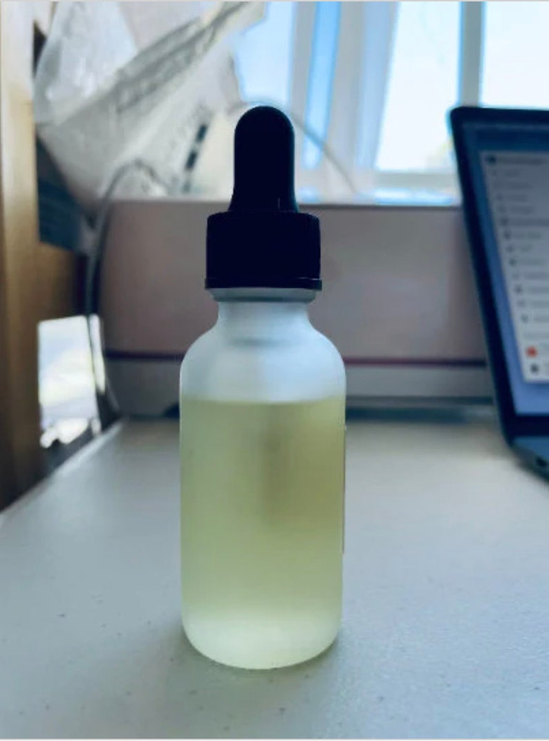 Pu&ograve; includere: Una bottiglia di vetro trasparente con una finitura opaca e un contagocce nero in cima. La bottiglia &egrave; piena di un liquido giallo chiaro.